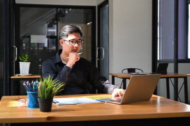 İşyerinde bilgisayarla çalışan başarılı bir iş adamı..