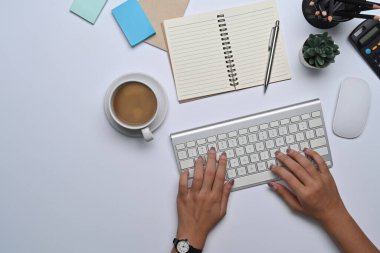 Ofis masasında oturan ve klavyeye yazan kadının üstünde..