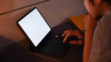 Kesilmiş kurşun delikanlısı rahat bir yatakta uzanıyor ve gece geç saatlerde bilgisayar tabletiyle çalışıyor..