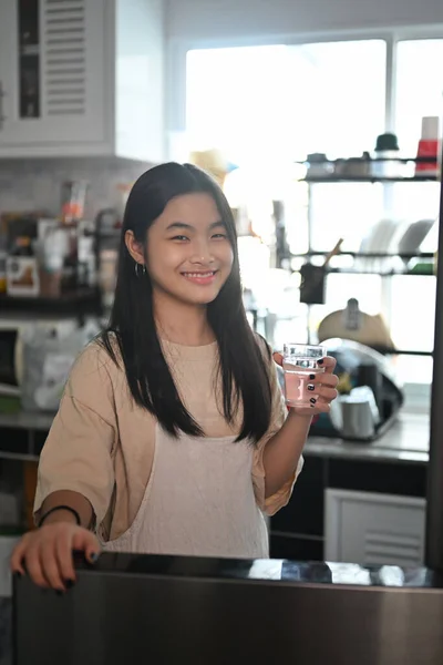부엌에서 물컵을 미소짓는 이시아 — 스톡 사진