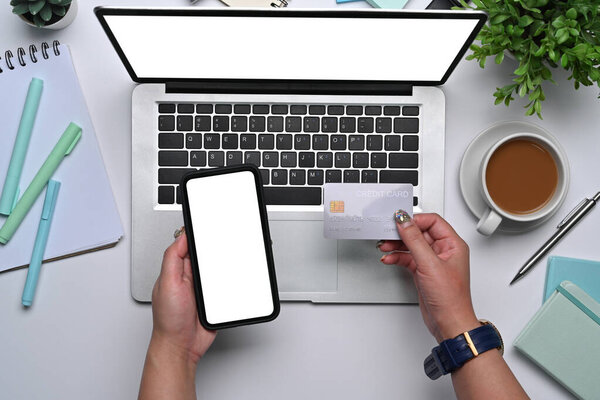 Вид сверху молодая женщина держит смартфон и кредитную карту.