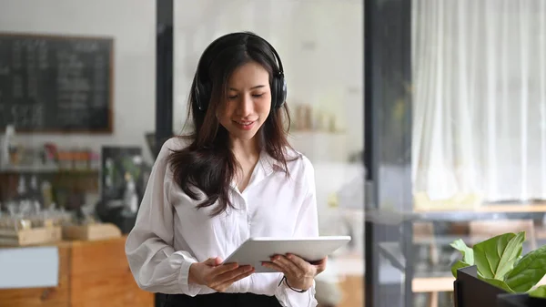 Pozytywna Azjatycka Kobieta Nosi Słuchawki Używa Tabletu Cyfrowego Kawiarni — Zdjęcie stockowe