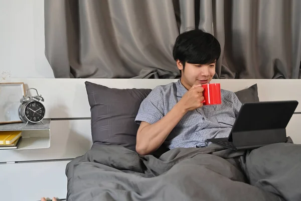 Młody Człowiek Pijący Kawę Surfujący Internecie Tabletem Cyfrowym Rano — Zdjęcie stockowe