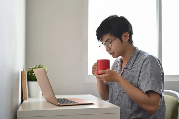 Lugn Asiatisk Man Pyjamas Med Dator Laptop Sovrum Och Dricka — Stockfoto