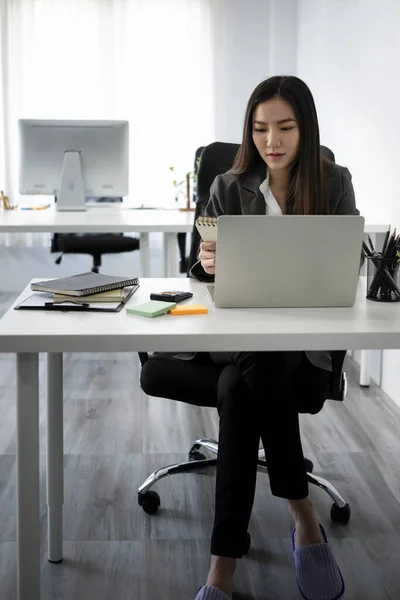オフィスの机に座って ラップトップコンピュータを使用して美しいビジネス女性の完全な長さの肖像画 — ストック写真