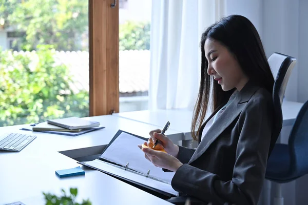 サイドビューアジアのビジネスマン女性作るノート上の付箋 — ストック写真