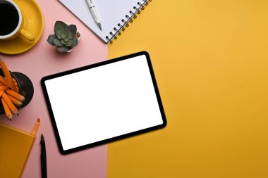 Beyaz ekranlı dijital tablet ve renkli arkaplanda malzemeler.