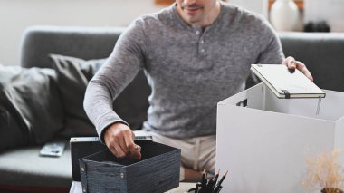 Kırpılmış çekim, gülen adam kaldırma günü için kişisel eşyalar hazırlıyor.. 