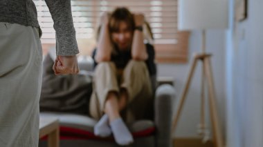 Arka planda ağlayan bir kadınla yumruk tokuşturan adam. Aile içi şiddet kavramı.