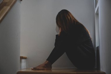 Depresyondan muzdarip yalnız bir kadın karanlık odada oturuyor..