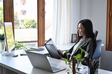 Güzel bir iş kadını işyerindeki mali belgeleri analiz ediyor..