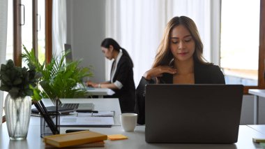 Ofiste dizüstü bilgisayarla çalışan güzel Asyalı kadın..