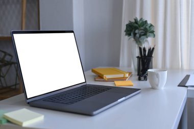 Beyaz ofis masasında boş görüntüsü olan bilgisayar laptopu.