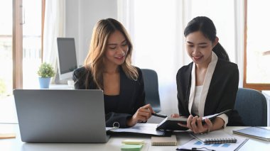 İki çekici iş kadını ofiste yeni proje planlaması hakkında konuşuyor..