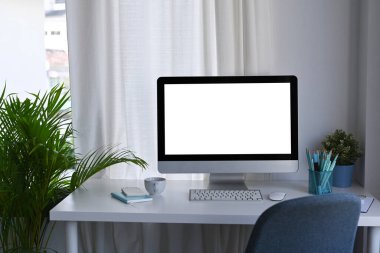 Bilgisayarlı modern işyeri, ve beyaz masada ofis malzemeleri..