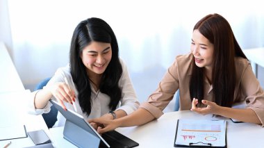 İki Asyalı iş kadını bilgisayar laptopuyla birlikte çalışıyor..