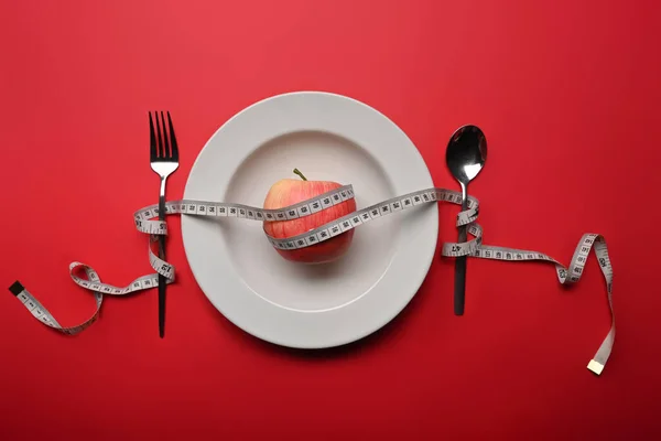 Schudnąć Zdrowej Koncepcji Diety Jabłko Taśma Łyżka Widelec Czerwonym Tle — Zdjęcie stockowe