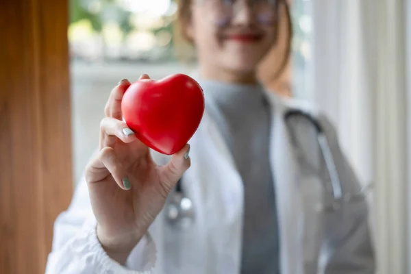 手握红心的听诊器 微笑着女医生 保健和医疗概念 — 图库照片