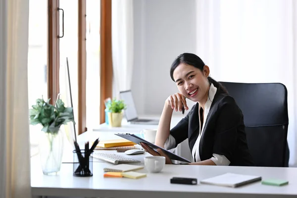 Εμπιστευτική Νεαρή Επιχειρηματίας Που Κάθεται Στο Γραφείο Της Και Χαμογελά — Φωτογραφία Αρχείου