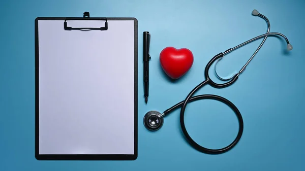剪贴板 听诊器和蓝色背景的红心 保健和医疗概念 — 图库照片