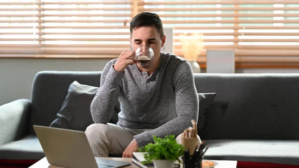 Genç Adam Kahve Içiyor Koltukta Bilgisayar Kullanıyor — Stok fotoğraf