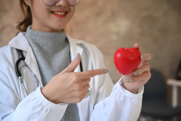 手に赤いハートの形をした笑顔の若い女性医師 医療の概念 — ストック写真