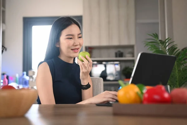Υγιής Νεαρή Γυναίκα Τρώει Μήλο Και Χρησιμοποιώντας Ψηφιακή Ταμπλέτα Στην — Φωτογραφία Αρχείου