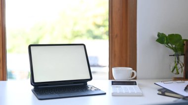 Sayısal tableti boş ekran, hesap makinesi, kahve fincanı ve belgeleri beyaz masa üzerine kopyala.