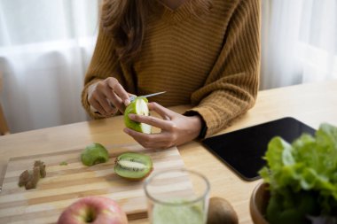 Mutfakta vejetaryen yemeği hazırlayan genç bir kadın..