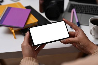 Yakından bak genç kadın elleri beyaz ekranlı akıllı telefon tutuyor..
