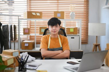 Portre girişimi küçük işletme girişimcisi ev ofisinde karton kutularla oturuyor..