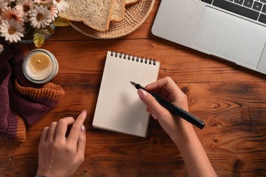 Boş deftere kalem ve yazı yazan yaratıcı kadın..