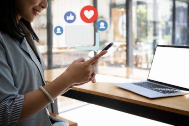İş kadını çevrimiçi toplulukta paylaşmak ve yorum yapmak için akıllı telefon kullanıyor.