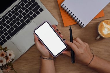 Beyaz ekranlı kalem ve model cep telefonu tutan kadın.