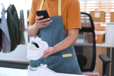 İnternette satmak için akıllı telefonla ürün fotoğrafı çeken bir adam. Çevrimiçi konsept satmak.