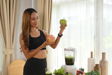 Mutfakta vejetaryen yemeği hazırlayan mutlu genç kadın..