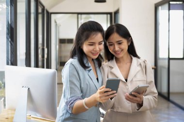 İki neşeli iş arkadaşı ofiste ara verip akıllı telefon kullanmışlar..