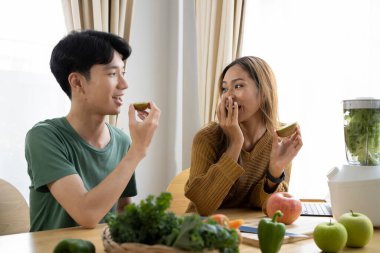 Mutlu genç çift mutfakta birlikte vejetaryen yemeği hazırlıyor..