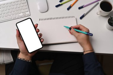 Akıllı telefonu tutan ve not defterine not alan yaratıcı kadını tepeden vurdu..