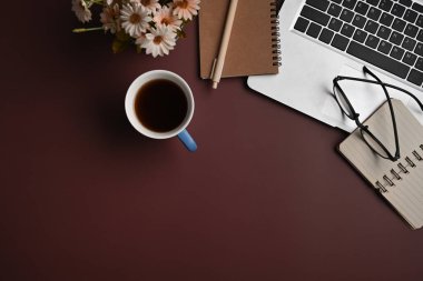 Dizüstü bilgisayar, dizüstü bilgisayar, mor arka planda bardak ve kahve fincanı. Düz yatıyordu.