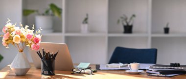 Bilgisayarı, saksısı, kahve fincanı ve ofis malzemeleri olan rahat bir iş yeri..