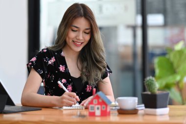 Modern ofiste çalışan çekici kadın finans danışmanı ya da emlakçı.