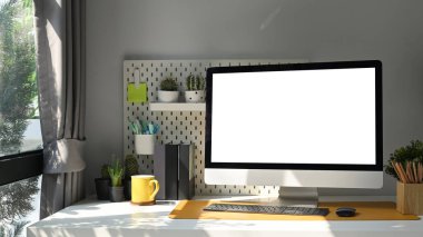 Bilgisayarı boş ekranla, bitki örtüsüyle ve malzemelerle oturma odasındaki beyaz masaya yerleştir.