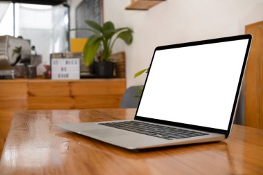 Kahve dükkanındaki ahşap masada beyaz ekranlı bilgisayar bilgisayarı..