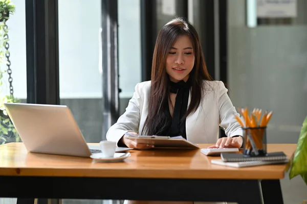 アジアのビジネス女性起業家はラップトップで作業し レポートを読む — ストック写真