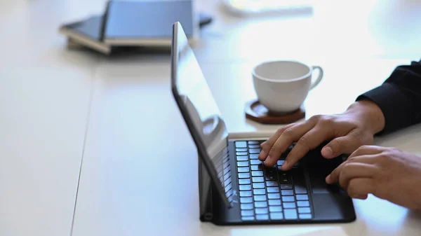ホワイトオフィスのデスクでコンピュータタブレットを使用している若いビジネスマン — ストック写真