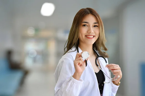 美丽的女医生形象 身穿白色制服 手持听诊器 对着相机微笑 — 图库照片