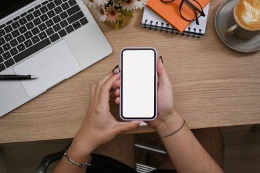 İş yerinde oturan ve akıllı telefon kullanan tepeden bakan yaratıcı adam.