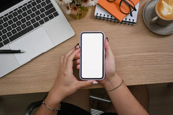 İş yerinde oturan ve akıllı telefon kullanan tepeden bakan yaratıcı adam.