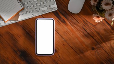 Akıllı telefon, kablosuz klavye, defter ve saksı. Düz yatıyordu.